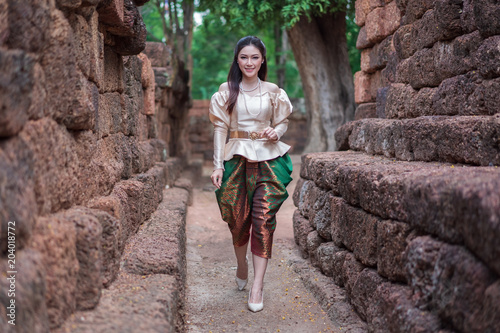 woman in Thai traditional dress is walking