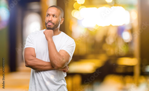 African american man with beard thinking thoughtful with smart face at night
