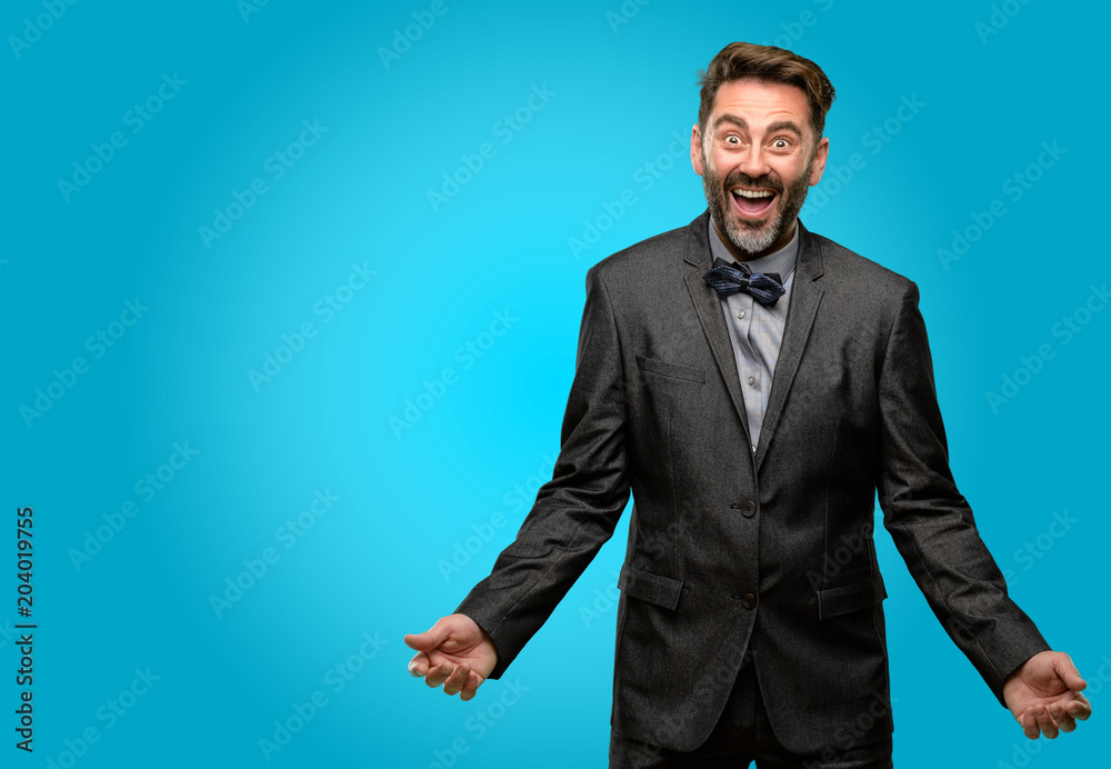 Middle age man, with beard and bow tie happy and surprised cheering expressing wow gesture Middle age man, with beard and bow tie happy and surprised cheering expressing wow gesture