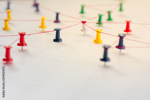 Linking entities, Network simulation, social media, Communications Network, The connection between the two networks. in paper linked together by cotton with a red yarn
