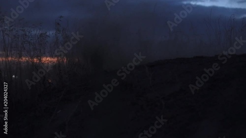 Motocross racer start riding at his dirt bike kicking up dirt and dust at night. Side view Slow motion 4k