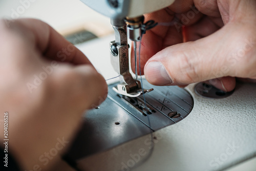 Fototapeta Naklejka Na Ścianę i Meble -  cropped shot of tailor working with sewing machine