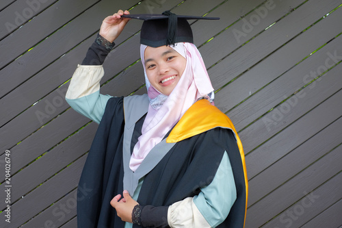 Fotografie Beautiful female Muslim wearing a convocation robe and posed in happiness style after graduated in University of Canterbury