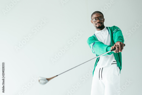 Fotografia stylish african american man in retro sportswear playing golf, isolated on white