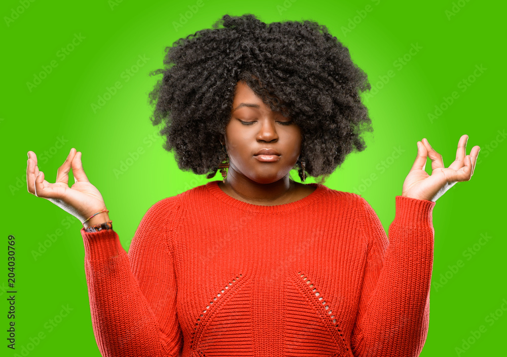 Beautiful african woman doing ok sign gesture with both hands expressing meditation and relaxation Beautiful african woman doing ok sign gesture with both hands expressing meditation and relaxation