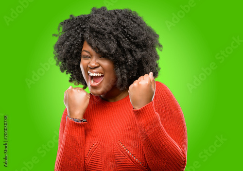 Beautiful african woman happy and excited expressing winning gesture. Successful and celebrating victory, triumphant