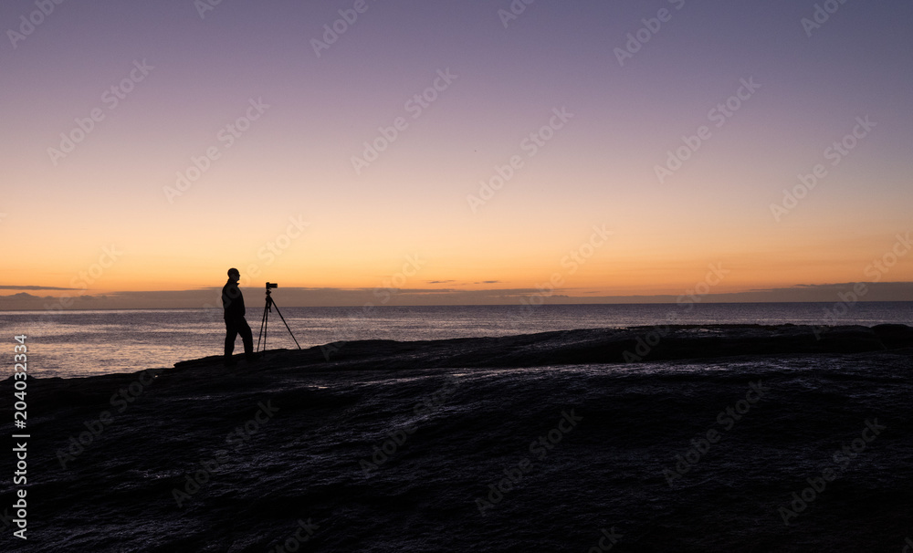 Photographer at dawn at the Bow Hole, Tasmania