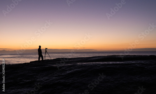 Photographer at dawn at the Bow Hole, Tasmania