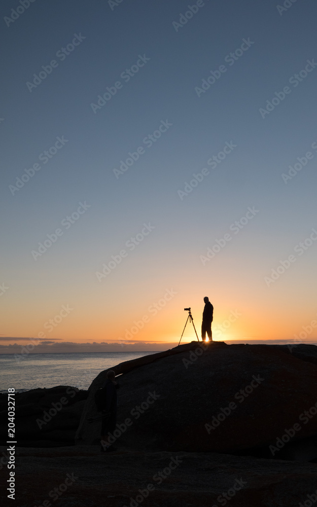 Photographer at dawn at the Bow Hole, Tasmania