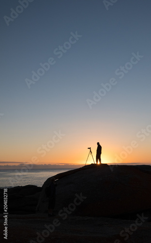 Photographer at dawn at the Bow Hole  Tasmania