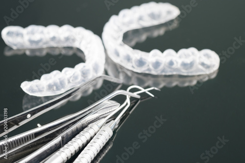 Dental tools and retainer orthodontic appliance on the black background.