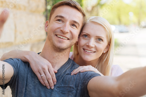 Outdoor selfie portrait of young cheerful couple