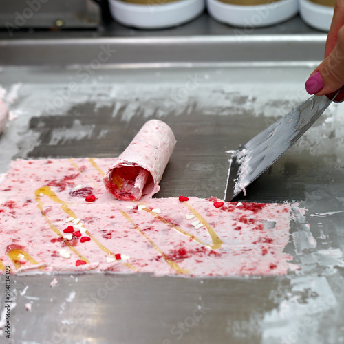 Thai roll ice cream is made by hand on the freezer. Sweet dessert made from natural berries and ingredients. The process of making food.