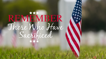 Small American flags and headstones at National cemetary- Memorial Day display - with copy