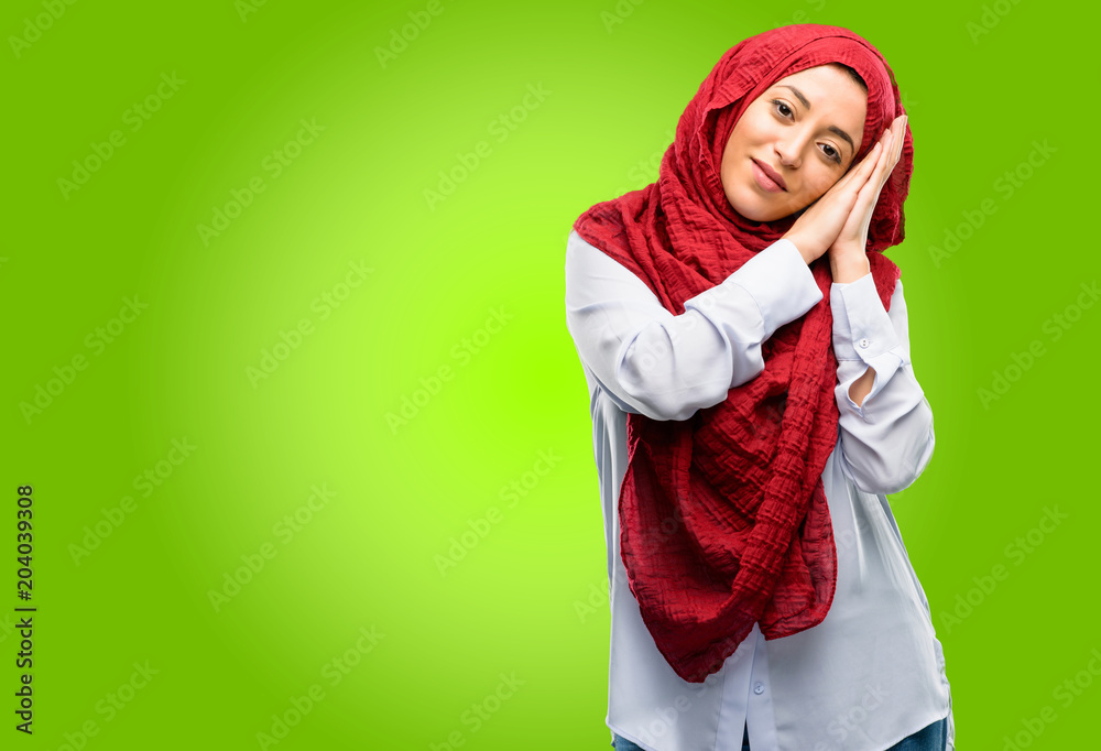 Young arab woman wearing hijab tired and bored, tired because of a long day overworking Young arab woman wearing hijab tired and bored, tired because of a long day overworking