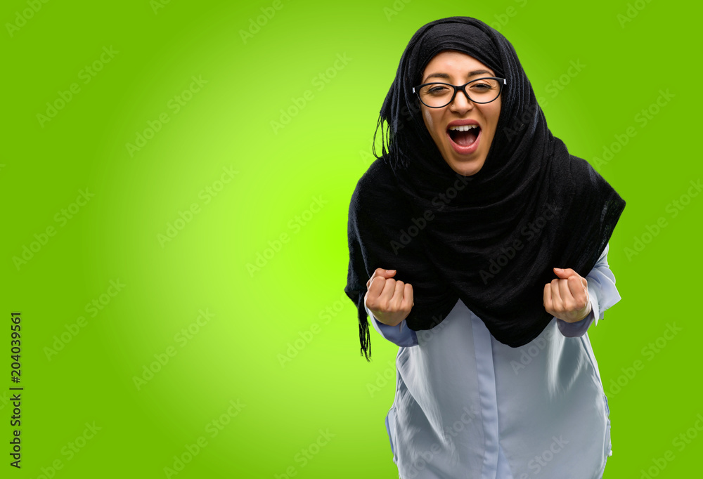 Young arab woman wearing hijab happy and excited celebrating victory expressing big success, power, energy and positive emotions. Celebrates new job joyful