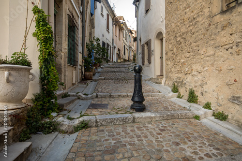Fototapeta Naklejka Na Ścianę i Meble -  Steps and narrow street in the old town of Arles in Provence in the South of France.