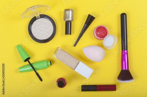 set of makeup cosmetics on yellow color background