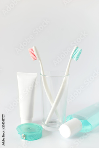 Toothbrushes, toothpaste, rinse and towel on white background. Dental and healthcare concept. Free copy space.