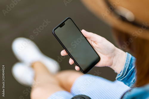 Bilde på lerret Woman holding a smartphone