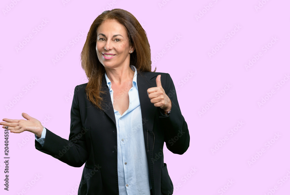 Middle age business woman thumb up holding something in his empty hand and making ok gesture Middle age business woman thumb up holding something in his empty hand and making ok gesture