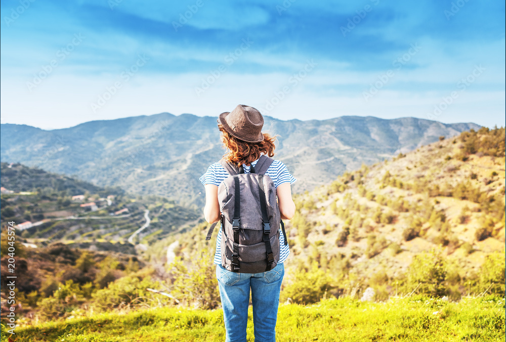 Wanderlust and travel concept. stylish traveler woman in hat looking at mountains. hipster girl traveling on top of mountain, looking in front. space for text. atmospheric moment