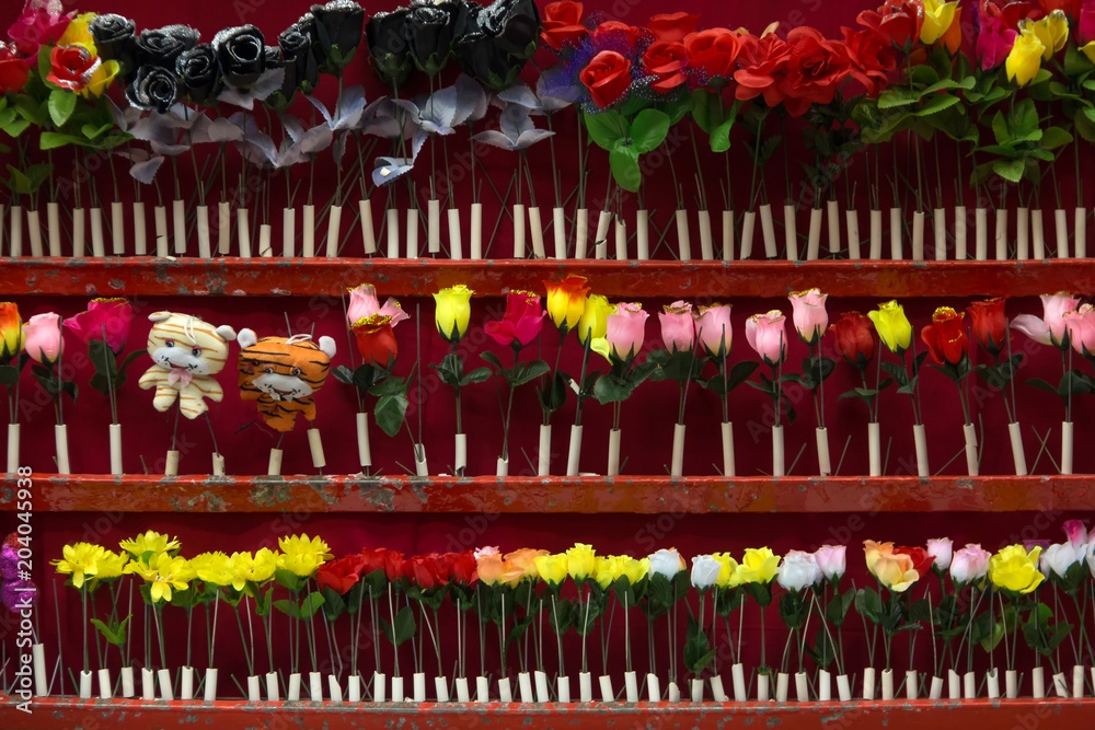 Schiessbude auf dem Jahrmarkt mit Kunstblumen