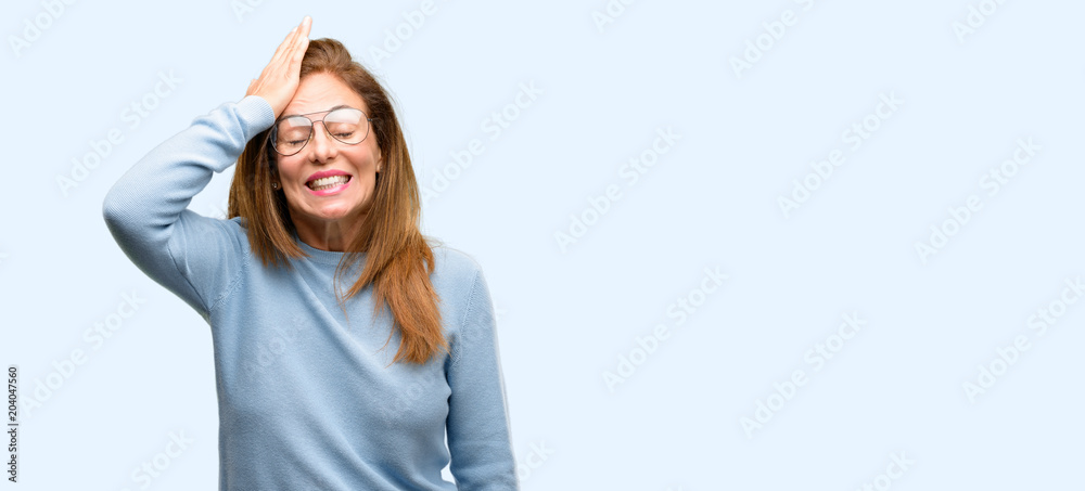Middle age woman wearing wool sweater and cool glasses terrified and nervous expressing anxiety and panic gesture, overwhelmed isolated blue background Middle age woman wearing wool sweater and cool glasses terrified and nervous expressing anxiety and panic gesture, overwhelmed isolated blue background