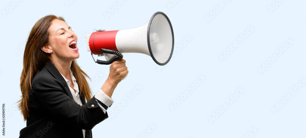 Middle age woman wearing jacket communicates shouting loud holding a megaphone, expressing success and positive concept, idea for marketing or sales isolated blue background Middle age woman wearing jacket communicates shouting loud holding a megaphone, expressing success and positive concept, idea for marketing or sales isolated blue background