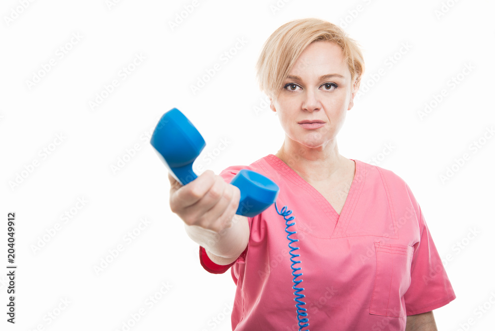 Female nurse wearing pink scrubs handing telephone receiver Female nurse wearing pink scrubs handing telephone receiver