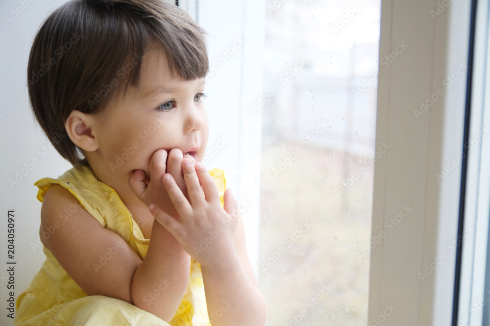 dreaming little girl portrait leans on elbows on window longing for something. happy smiling child thinking about pleasing thoughts dreaming little girl portrait leans on elbows on window longing for something. happy smiling child thinking about pleasing thoughts