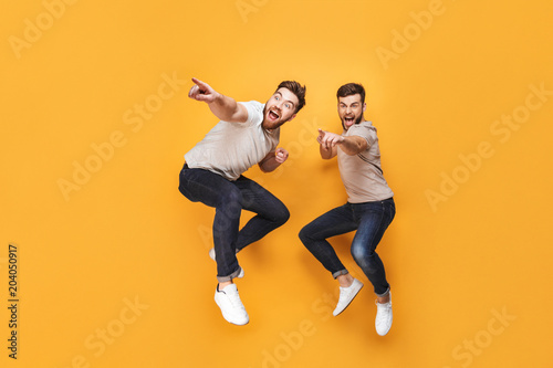 Two young excited men jumping together