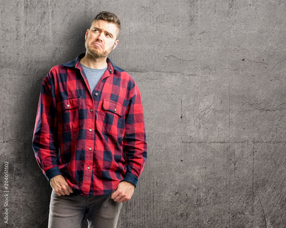 Young handsome man doubt expression, confuse and wonder concept, uncertain future