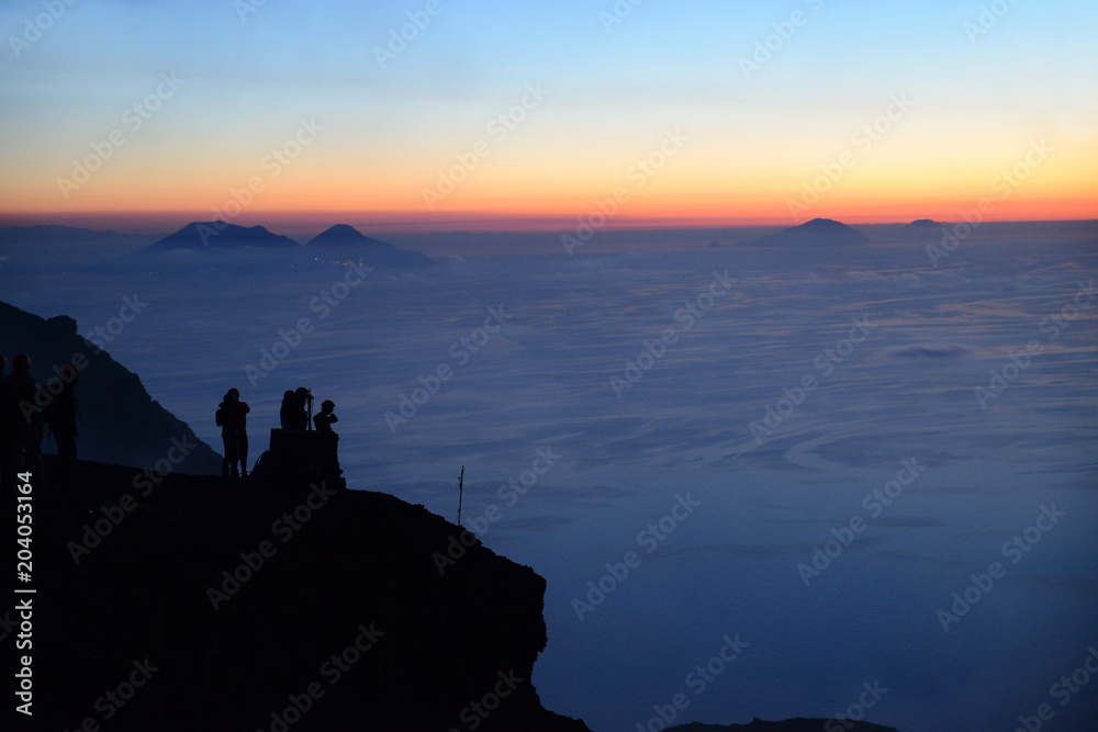Pleople on the summit of Volcano Stromboli enjoying the sunset and view of the Aeolian Islands, Sicily, Italy