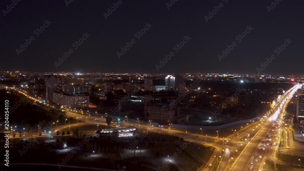 Aerial view of the night city, warm night lights traffic on the road.