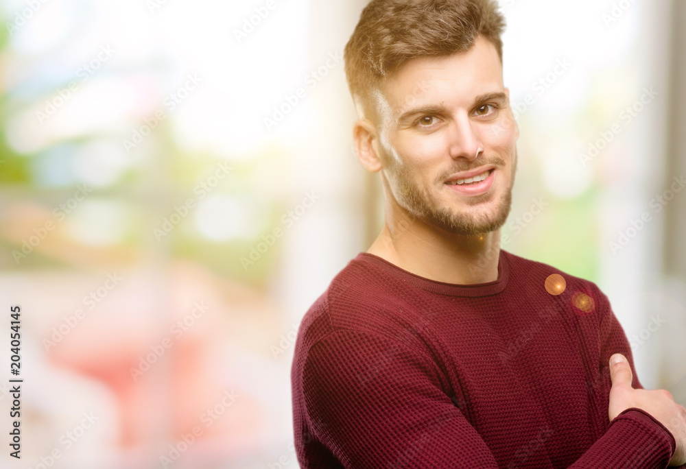 Handsome young man confident and happy with a big natural smile laughing, natural expression Handsome young man confident and happy with a big natural smile laughing, natural expression