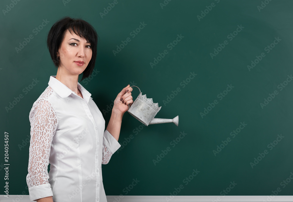 a woman with a watering can on the background boards, empty space for your picture a woman with a watering can on the background boards, empty space for your picture