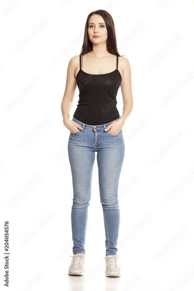 young woman in jeans and shirt stands on a white background young woman in jeans and shirt stands on a white background