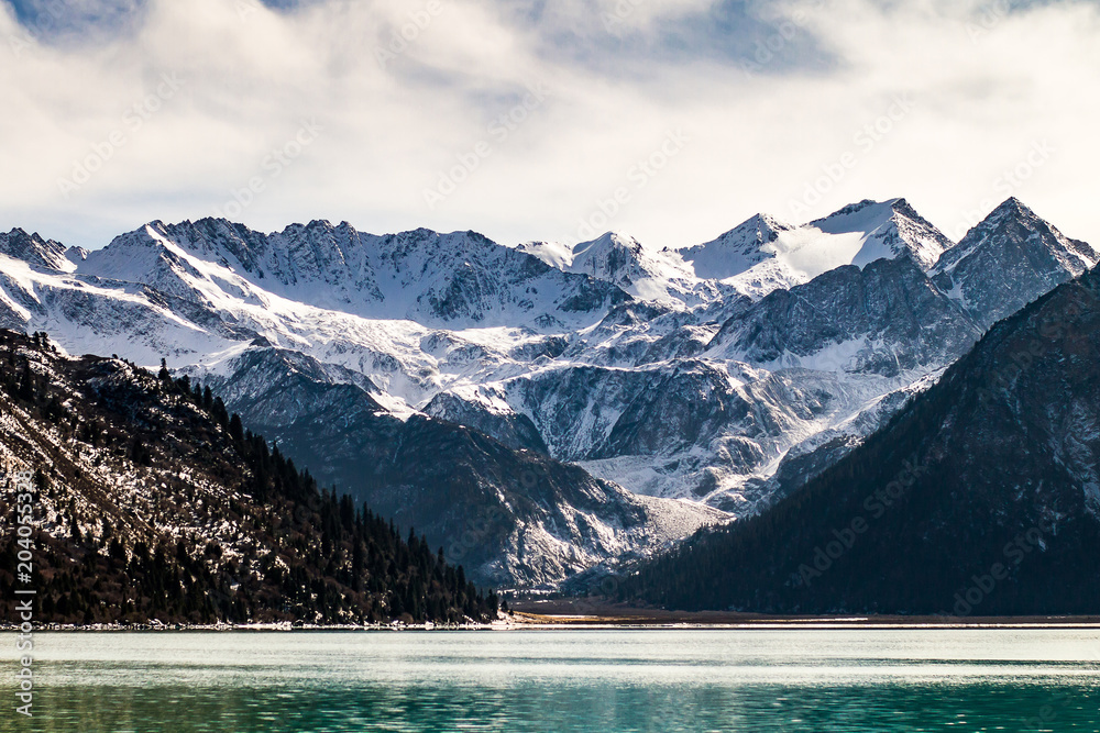 Beautiful winter landscape with lake and snow mountain