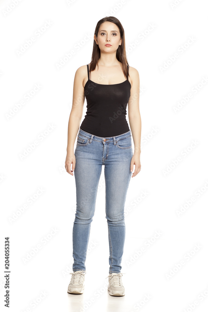 young woman in jeans and shirt stands on a white background young woman in jeans and shirt stands on a white background