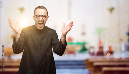 Priest religion man happy and surprised cheering expressing wow gesture at church