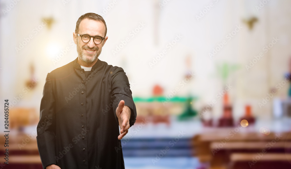 Priest religion man holds hands welcoming in handshake pose, expressing trust and success concept, greeting at church - obrazy, fototapety, plakaty 