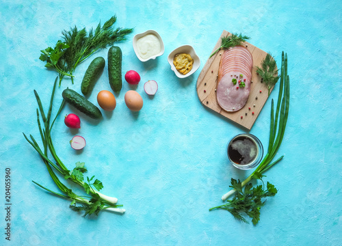 A set of ingredients for cold okroshka soup on a blue background. The view from the top.