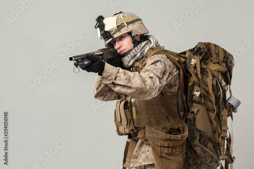 Soldier in camouflage holding rifle