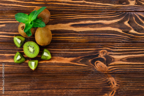 Fresh kiwi fruits on a wooden background. Space for text or design.