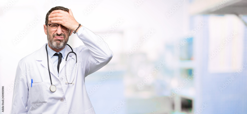 Doctor senior man, medical professional terrified and nervous expressing anxiety and panic gesture, overwhelmed at hospital