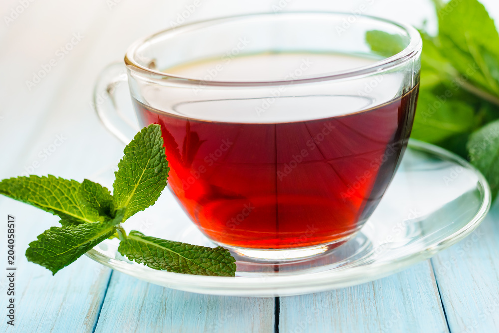 Glass cup of tea and fresh mint leaves Glass cup of tea and fresh mint leaves