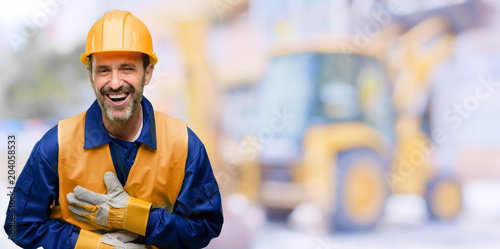 Senior engineer man, construction worker confident and happy with a big natural smile laughing at work