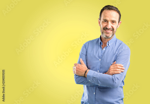 Handsome middle age man with crossed arms confident and happy with a big natural smile laughing © Krakenimages.com