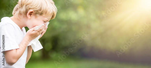 Kind mit Allergie beim Niesen in Taschentuch